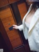 A woman in a white suit holding a credit card.