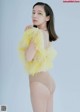 A woman in a yellow feather boa posing for a picture.