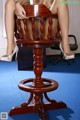 A woman sitting on top of a wooden chair.