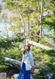 A woman standing on a log in the woods.